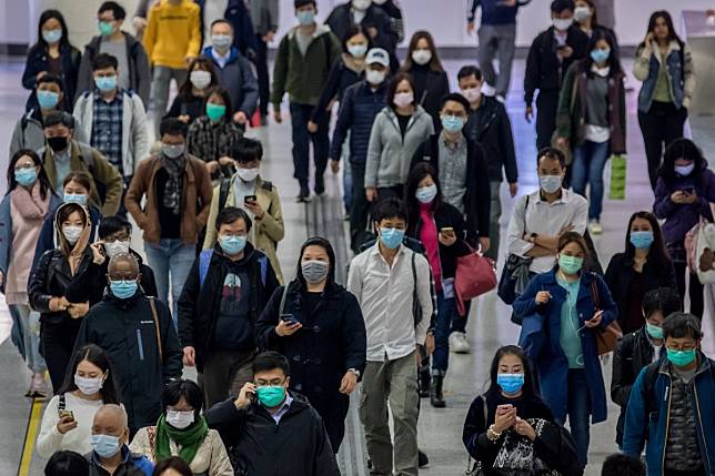 Commuters in protective masks walk through an MTR station in Hong Kong. Photo: Bloomberg