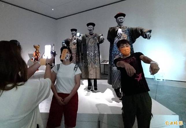 不少參觀遊客也跟著「裝神弄鬼」，與穿著中國清朝服飾的「3隻殭屍」一起合影拍照。(記者蔡文居攝)