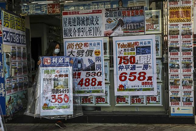 A property agency staff set the advertising board in front of the shop in Yuen Long on 17 February 2020. Photo: KY Cheng