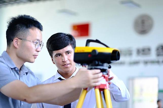 A teacher (L) from Tianjin Urban Construction Management &amp; Vocation Technology College gives instructions to a student at the Luban Workshop in Dushanbe, Tajikistan, June 14, 2024. (Xinhua/Zheng Kaijun)