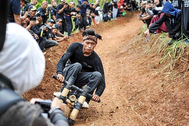 A participant rides a traditional wooden cart, locally known as kadaplak, downhill at Cisurupan in Bandung, West Java Province, Indonesia, Nov. 28, 2024. (Photo by Septianjar Muharam/Xinhua)