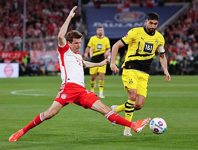 Thomas Mueller (L) of Bayern Munich vies with Emre Can of Borussia Dortmund during the German first division football match in Munich, Germany, March 30, 2024. (Photo by Philippe Ruiz/Xinhua)