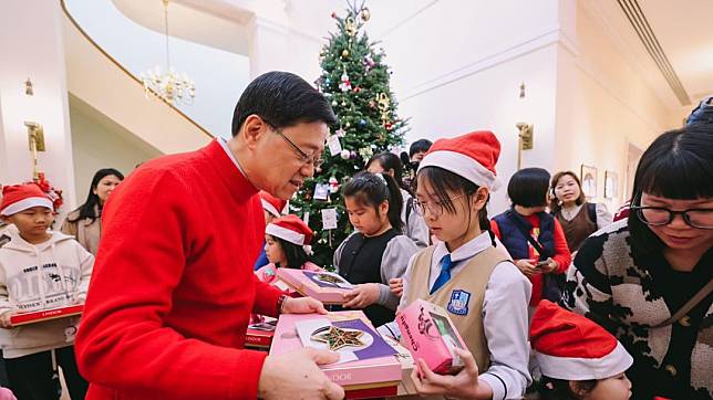 李家超(左)向社區客廳家庭的小朋友送聖誕禮物