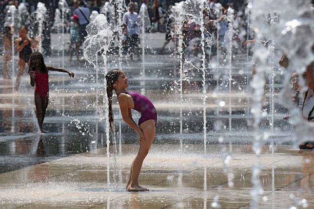 近年歐洲經常被熱浪侵襲，圖為2015年7月，一群孩子在法國南部尼斯的廣場噴泉戲水（AP）