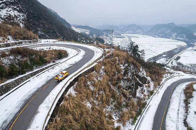 A drone photo taken on Feb. 6, 2024 shows workers spreading salt on the highway in Cili County, Zhangjiajie City of central China's Hunan Province. (Xinhua/Chen Sihan)