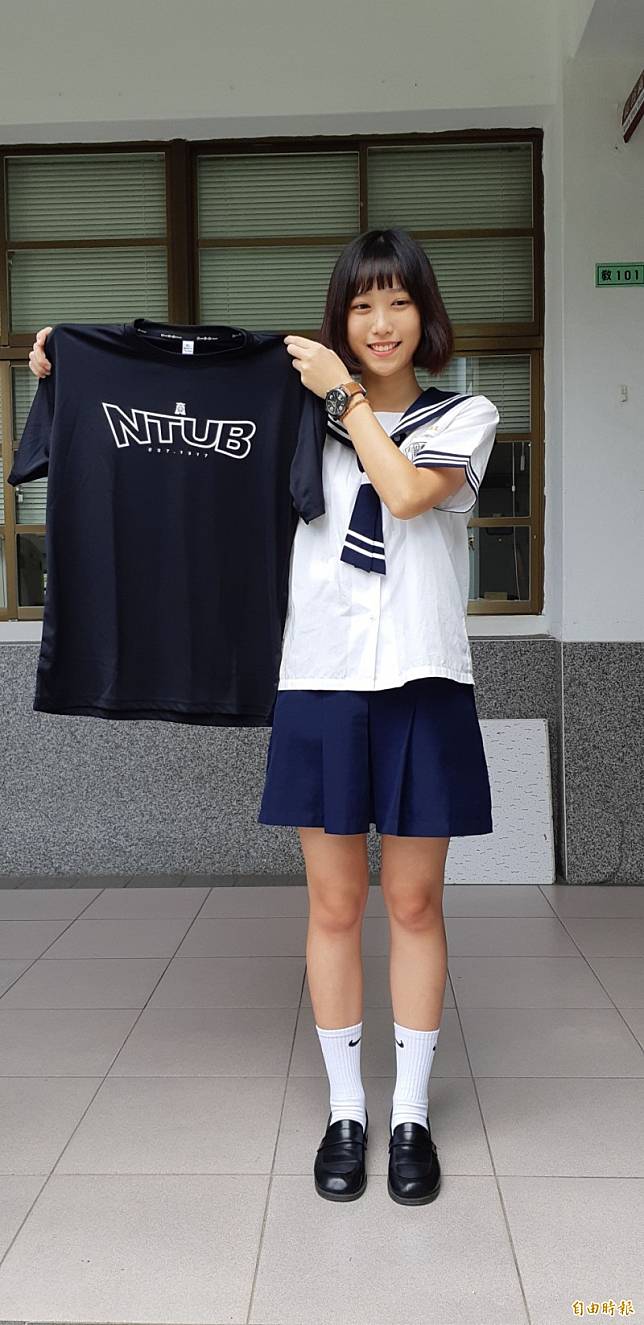 台東高商學生呂培郁穿著東商水手服，開心展示國立台北商業大學的T恤。(記者黃明堂攝)