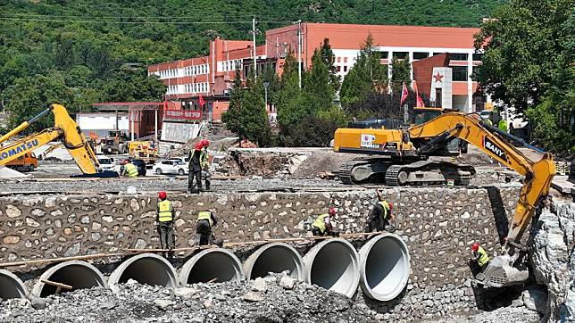 This aerial photo taken on Aug. 23, 2023 shows construction workers repairing a bridge in front of the Xiayunling central primary school in Fangshan District of Beijing, capital of China.