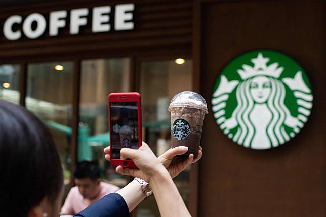 A woman taking a picture of her beverage at a Starbucks coffee shop in Beijing. Photo: AFP