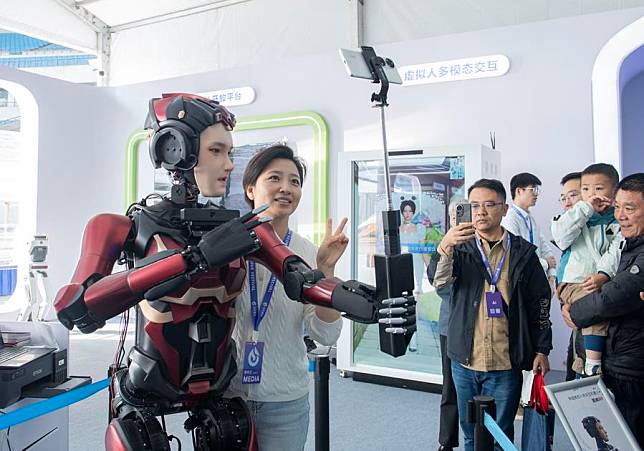 A humanoid robot takes selfies with a visitor at the 7th World Voice Expo in Hefei, east China's Anhui Province, Oct. 24, 2024. (Xinhua/Fu Tian)