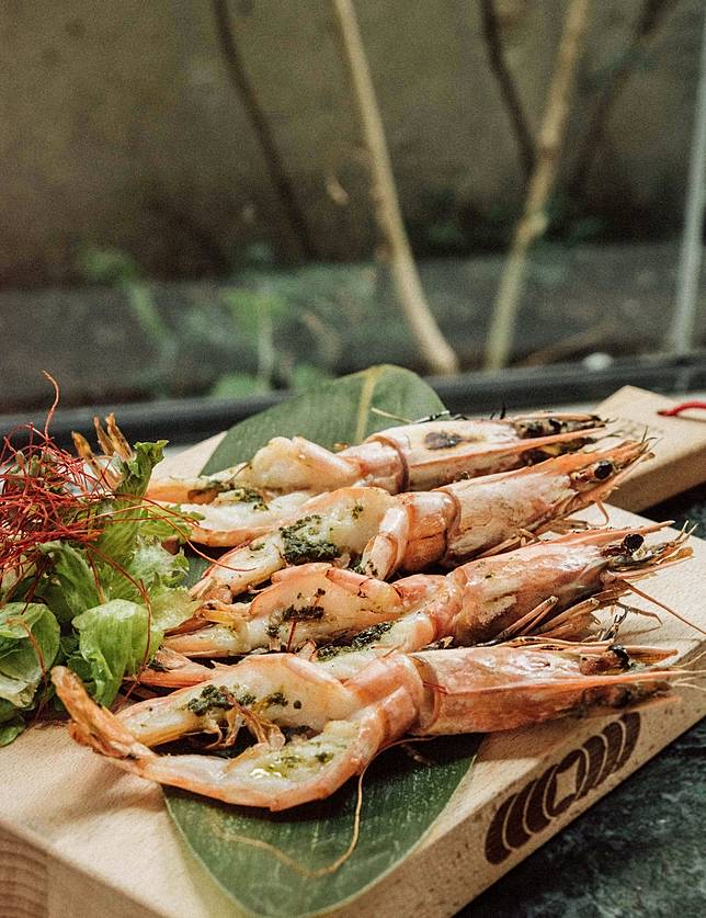 選用來自臺南的青農水產品牌《一夫水產》，以堅持無抗生素等用藥的悉心養殖技術下，培育出蝦肉媲美龍蝦、生鮮呈現透亮藍寶石色澤的「藍寶石草蝦」，特以「香烤特選藍寶石草蝦」呈現草蝦原味。（圖/貳房苑LivinGreen）