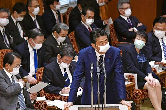 日本首相安倍晉三與大部分的國會議員終於戴上口罩。（美聯社）