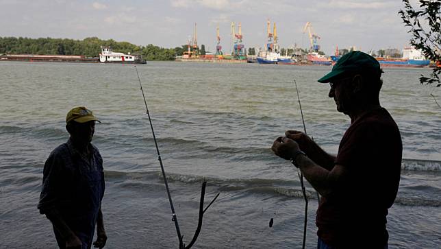 2名羅馬尼亞男子在多瑙河畔的普勞魯（Plauru）釣魚。資料照。路透社