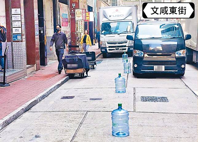 商戶用蒸餾水樽霸佔路面，導致其他車輛難以靠近行人路上落客。