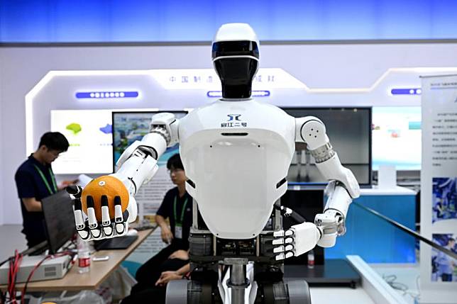 A humanoid robot hands an orange to a visitor at the 2024 World Manufacturing Convention in Hefei, east China's Anhui Province, Sept. 20, 2024. (Xinhua/Huang Bohan)