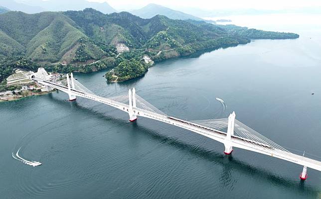 An aerial drone photo shows trains running on the Taipinghu grand bridge along the Chizhou-Huangshan Railway in east China's Anhui Province, April 26, 2024. (Photo by Gu Shaoyuan/Xinhua)