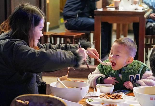 Tourists have rice noodles at a restaurant on a street at night in Kunming City, southwest China's Yunnan Province, Dec. 6, 2024. (Xinhua/Wang Jingyi)