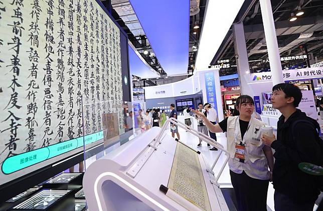 A staff member introduces the use of AIGC technology in ancient book restoration to a visitor during the 2024 World AI Conference in Shanghai, east China, July 6, 2024. (Xinhua/Fang Zhe)