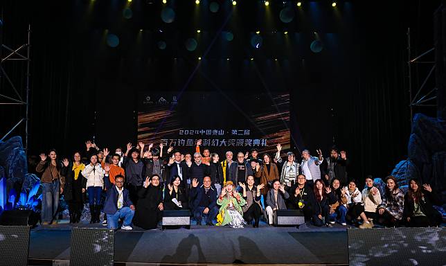 Winners and participants of the second Fishing Fortress Science Fiction Awards pose for a group photo on stage in Tai'an, east China's Shandong Province, Nov. 10, 2024. (Xinhua/Han Song)