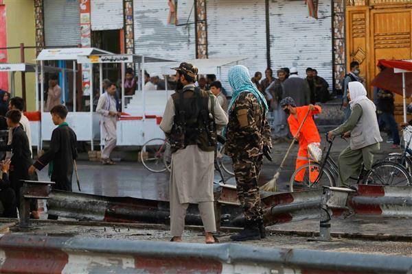 喀布爾街頭連續兩天發生爆炸，神學士武裝人員站崗，穿橘色工作服的人員正清理爆炸現場。路透社