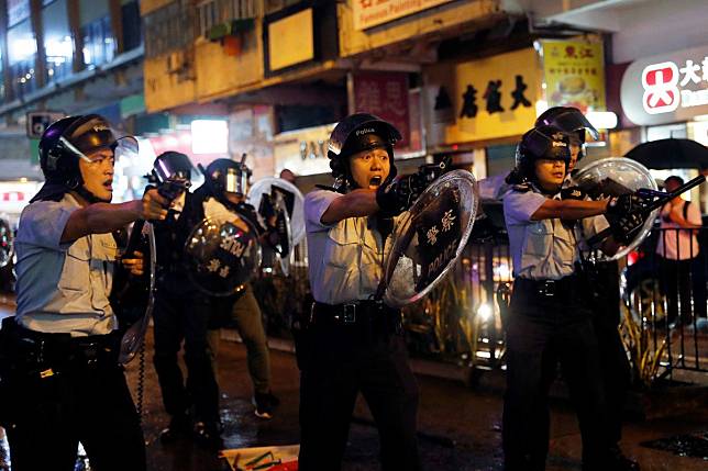 Police officers point their guns at anti-government protesters in Tsuen Wan on Sunday. Photo: Reuters
