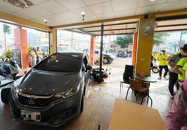 台中市大里區昨日發生一輛轎車撞進早餐店事故，其中一位帶著就讀小學孩子的家長正在用餐趕緊抱起孩子，逃過一劫。（記者陳金龍翻攝）