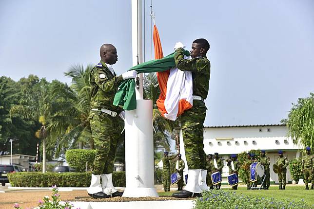 Ivorian soldiers rise an Ivorian flag during an official handover ceremony at the military camp in Abidjan, Cote d'Ivoire, on Feb. 20, 2025. (Photo by Yvan Sonh/Xinhua)