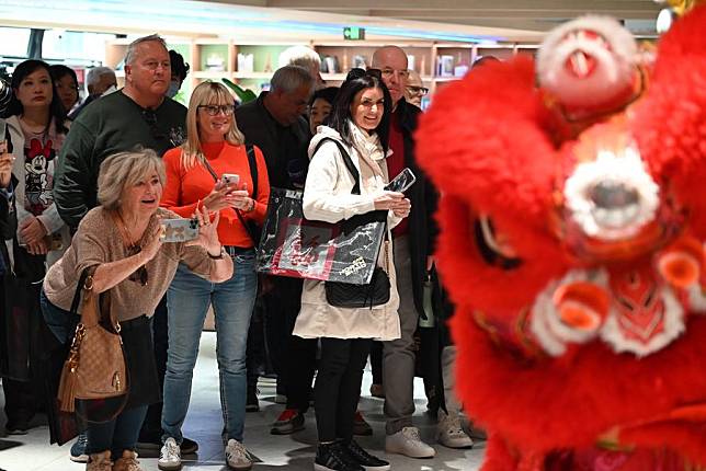 Inbound tourists arriving by cruise ship watch a lion dance performance in Shanghai, east China, Jan. 8, 2025. (Xinhua/Chen Aiping)