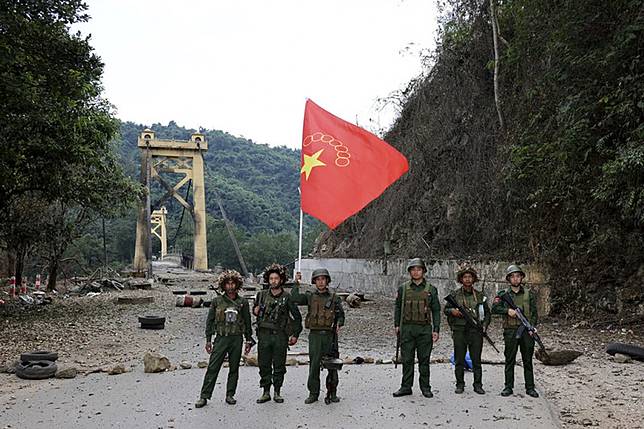 2023年11月12日，緬甸民族民主同盟軍成員在緬甸撣邦與該組織旗幟合影。（AP）