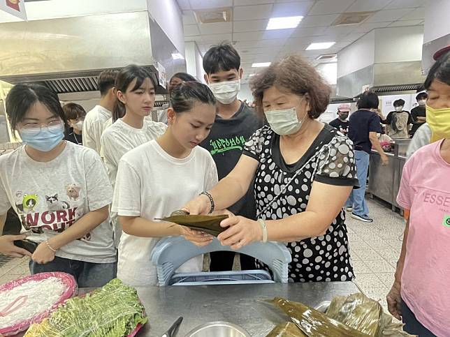 嘉藥越南籍學生學習台灣傳統肉粽包法。（記者黃文記攝）