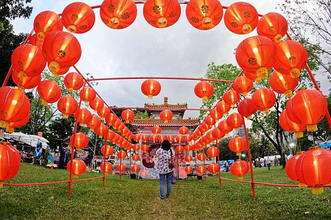 A visitor takes photos of the miniature of a building from Songkhla Province during the 40th Thailand Tourism Festival at Lumpini Park in Bangkok, Thailand, Feb. 22, 2022. (Xinhua/Wang Teng)