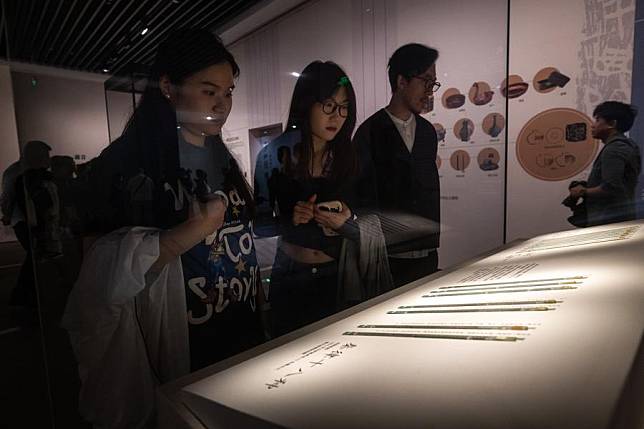 People visit an exhibition of bamboo slips discovered at the tomb of a local official back in the Qin Dynasty (221 BC-207 BC), at the Hubei provincial museum in Wuhan, central China's Hubei Province, on April 30, 2024. (Xinhua/Xiao Yijiu)