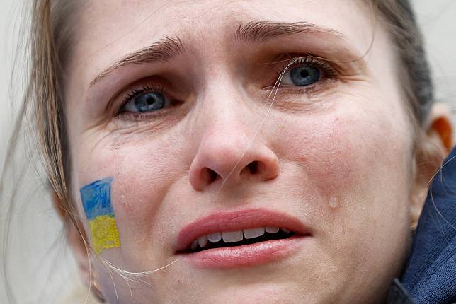 24號，英國倫敦一場支持烏克蘭的示威中，一位在臉上畫了烏克蘭國旗的民眾流下了淚水。 路透社 / 達志影像