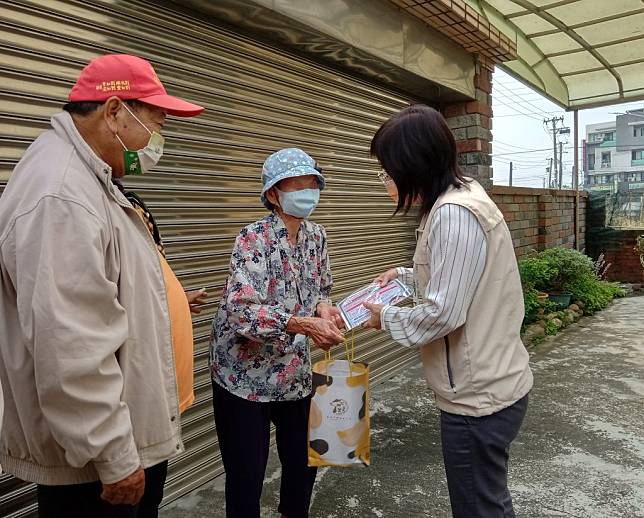 疫情持續升溫，柳營區長陳玉惠（右）偕同里長前往獨居長者家中，發送COVID-19肺炎關懷單跟關懷口罩。（柳營區公所提供）