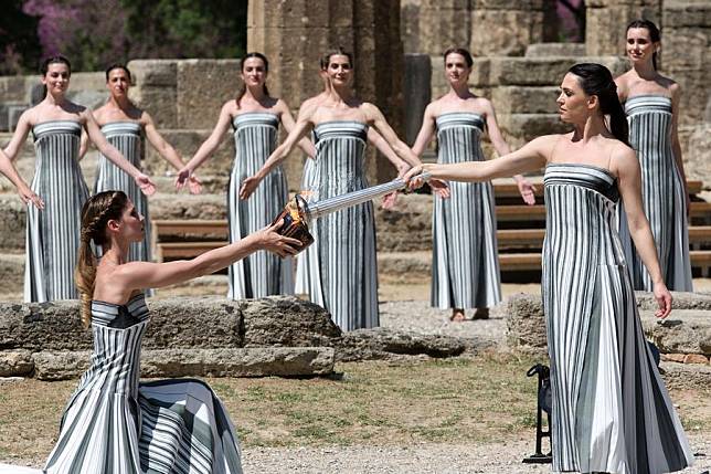 Greek actress Mary Mina (front R), playing the role of the High Priestess, lights the flame during the final dress rehearsal of the Olympic flame lighting ceremony for the 2024 Paris Olympic Games in Ancient Olympia, Greece, on April 15, 2024. (Xinhua/Marios Lolos)