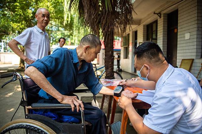 A medical worker (1st R) conducts medical examination for a senior resident at a nursing home in Anxiang County of Changde City, central China's Hunan Province, June 21, 2023. (Xinhua/Chen Sihan)