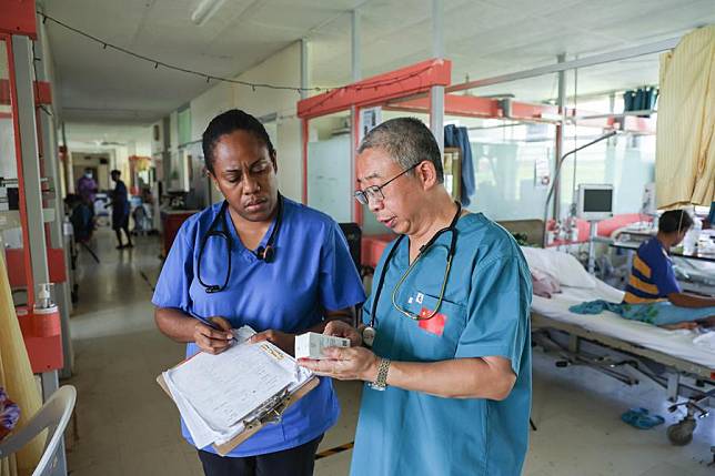 Chen Mulei &reg;, a cardiovascular physician and leader of the Chinese medical team, communicates with a local medical worker at Vila Central, the main hospital in Port Vila, Vanuatu, on Jan. 2, 2025. (Xinhua/Long Lei)