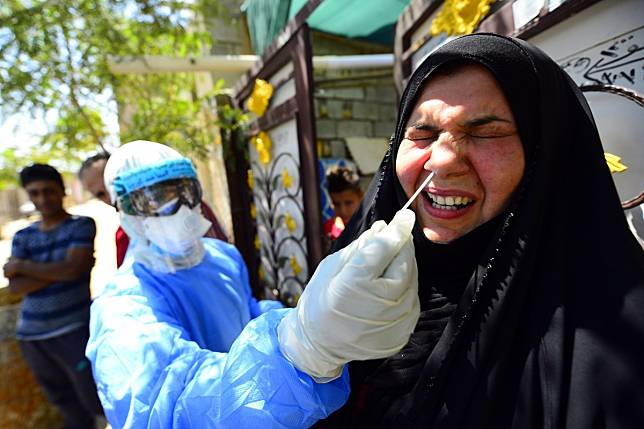 A medic takes a nasal swab from a woman in Iraq's central shrine city of Najaf. Photo: AFP