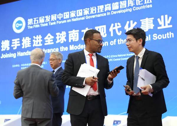 Endalkachew Sime (second right), former state minister of planning and development of Ethiopia, talks with Zhou Taidong, vice-president of the Center for International Knowledge on Development at the Fifth Think Tank Forum on National Governance in Developing Countries in Beijing on Friday.