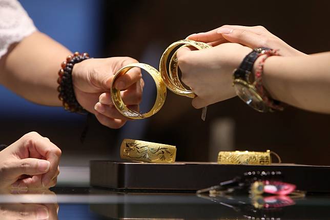 A customer inspects gold bangles at a jewellery store in Tsim Sha Tsui. Photo: Winson Wong