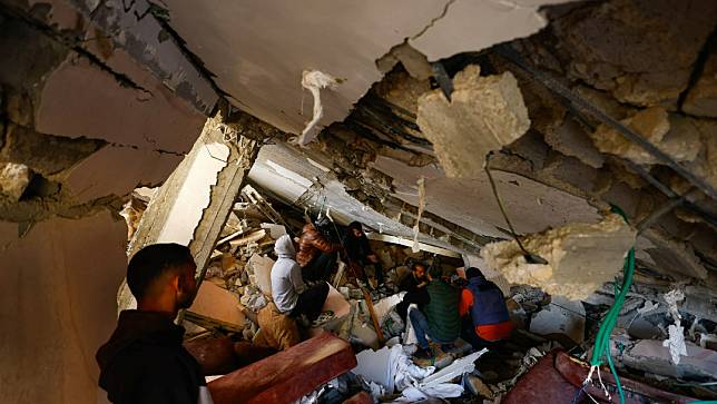 以色列軍方對加薩走廊南部城市拉法市發動空襲，民眾在廢墟中找尋生還者。路透社