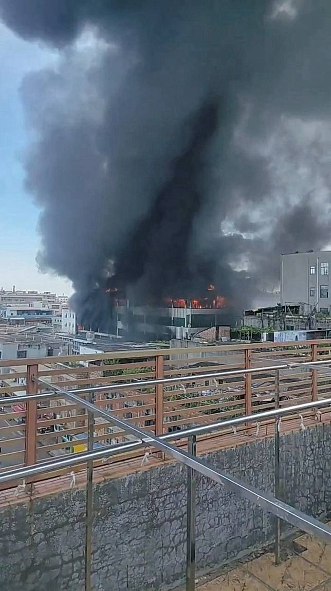 中國福建晉江市一座製鞋工廠9日中午突然發生大火，許多工人受困樓頂等待救援。路透社