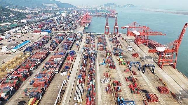 This aerial drone photo taken on May 9, 2024 shows containers being transported at the container terminal of Lianyungang Port, east China's Jiangsu Province. (Photo by Geng Yuhe/Xinhua)