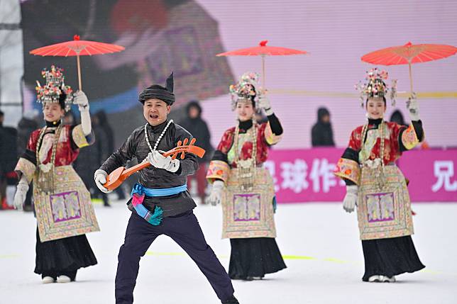 Artists from Rongjiang County, southwest China's Guizhou Province, perform during the half-time break of a friendly football match between Jilin City's Fengman district football team and Rongjiang County's &ldquo;Village Super League&rdquo; football team from southwest China's Guizhou Province held on the snowfield in Nanyang Village of Shulan City, northeast China's Jilin Province on Dec. 23, 2024. (Xinhua/Yan Linyun)