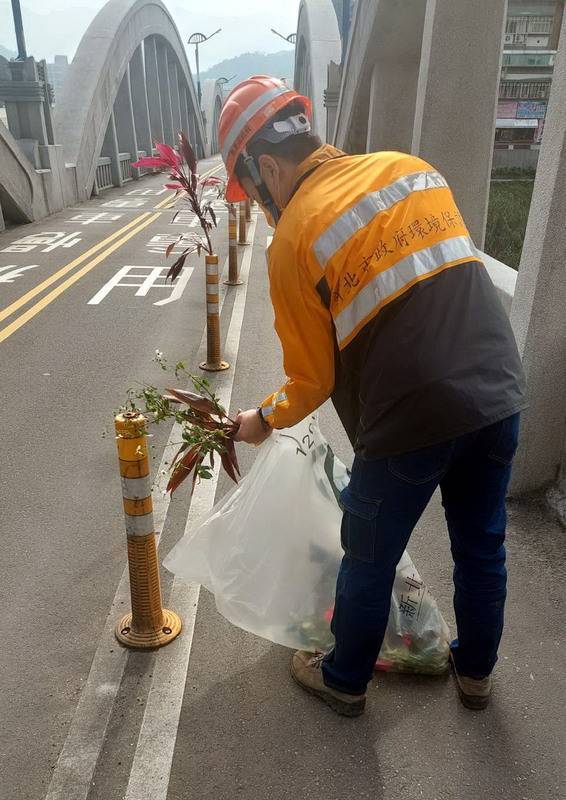 有民眾在新北市定古蹟三峽拱橋的交通防撞桿上插入花草，三峽區公所獲知後已請清潔隊員前往移除，以免影響用路人視線與交通安全。 （三峽區公所提供） 中央社記者黃旭昇新北市傳真 112年1月12日  
