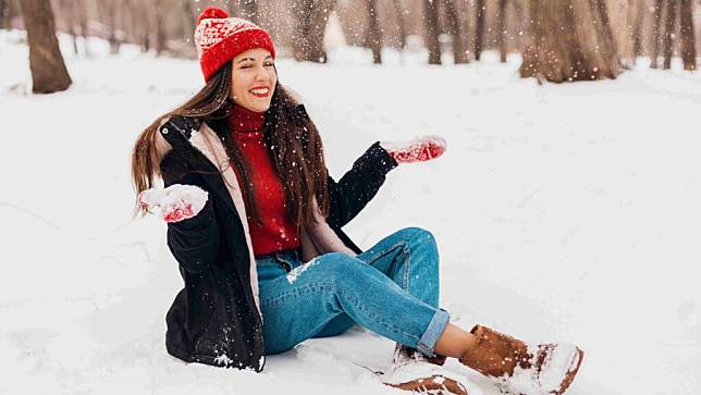 雪靴推薦＿一名穿著雪靴的女人坐在雪地上
