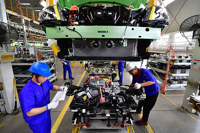 Workers install the electric motor for a new energy vehicle plant of BYD Auto in Xi'an, Shaanxi Province. Photo: Xinhua