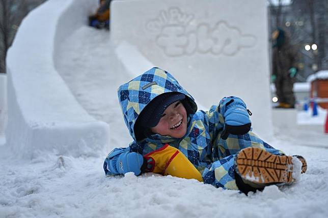 A kid slides down a snow slide during the 73rd Sapporo Snow Festival at Odori Park in Sapporo, Japan, Feb. 6, 2023. (Xinhua/Zhang Xiaoyu)