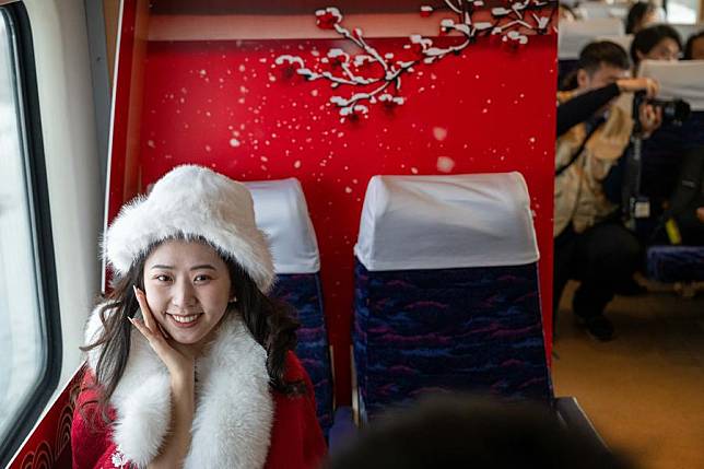 A dressed-up passenger poses for photos on the train K5197 in northeast China's Heilongjiang Province, Jan. 2, 2025. (Xinhua/Zhang Tao)