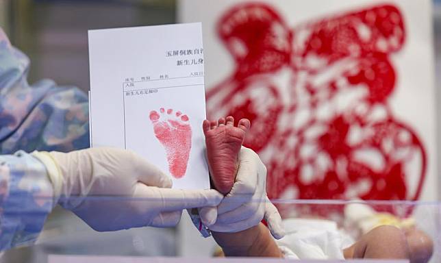 A newborn baby, whose Chinese zodiac sign is dragon, is seen with the baby's footprint at a hospital in Yuping Dong Autonomous County of Tongren, southwest China's Guizhou Province, Feb. 10, 2024, the Chinese Lunar New Year's Day. (Photo by Hu Panxue/Xinhua)