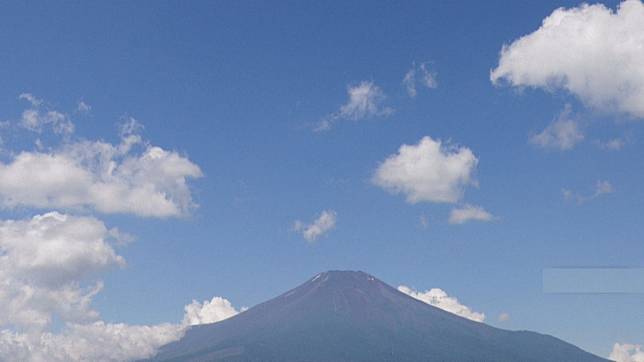 富士山登山步道長期人滿為患，山梨縣政府正研擬從今年7月開始，向每位登山客開徵通行費。（AFP）